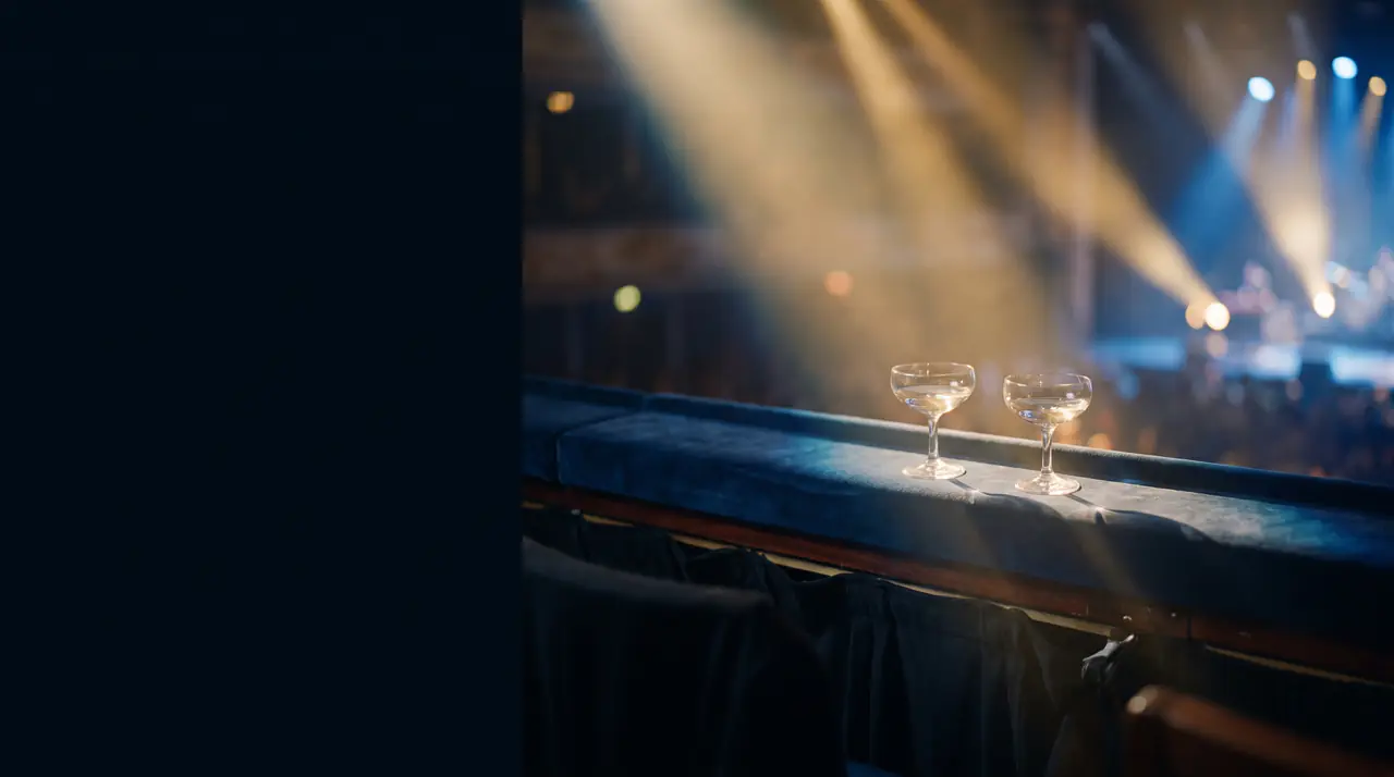 Two coupes on a velvet box ledge with concert lights beaming through haze